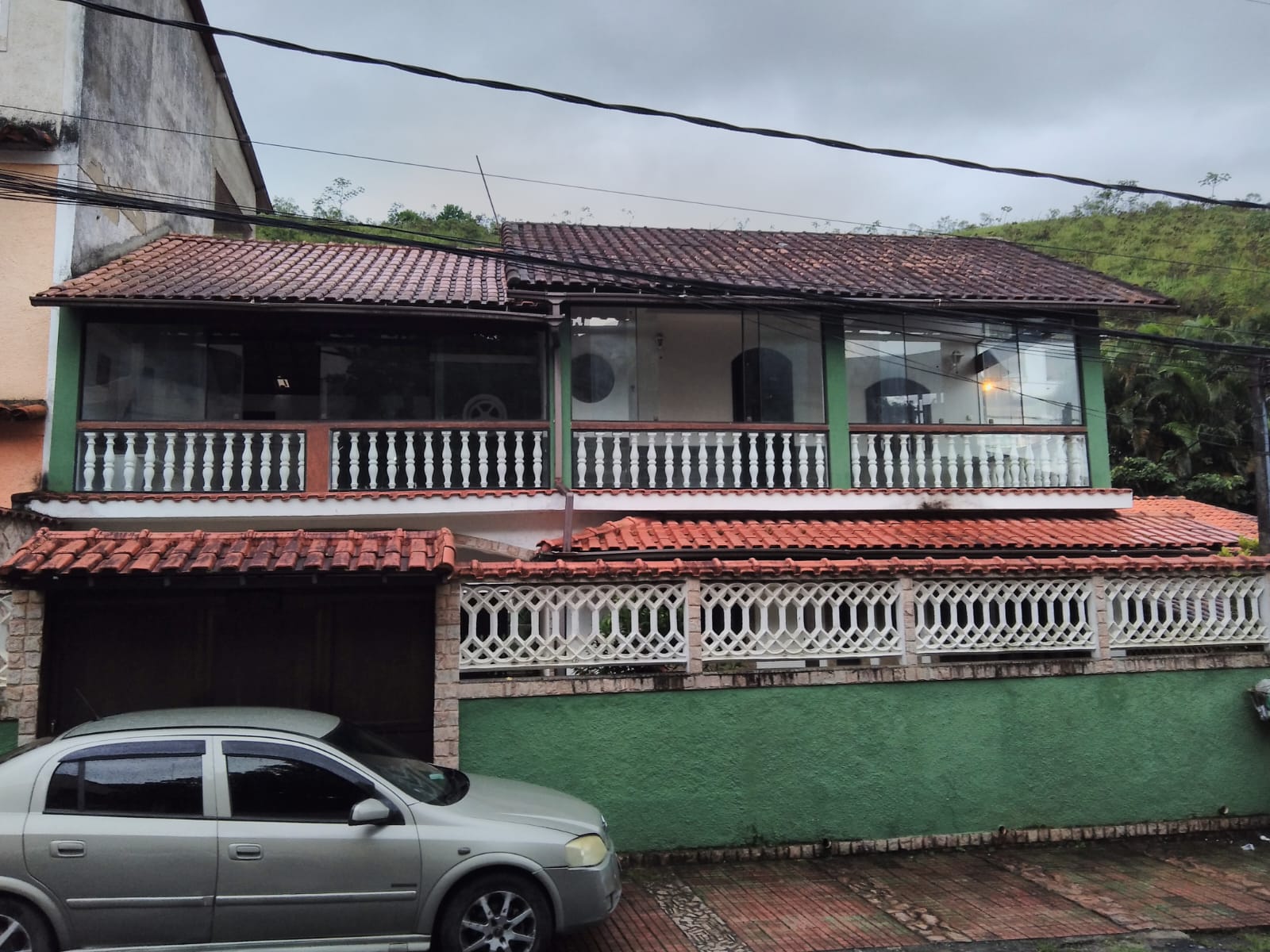 Fachada da Pousada Renascer com arquitetura rústica e charmosa, cercada por jardins floridos e árvores nativas